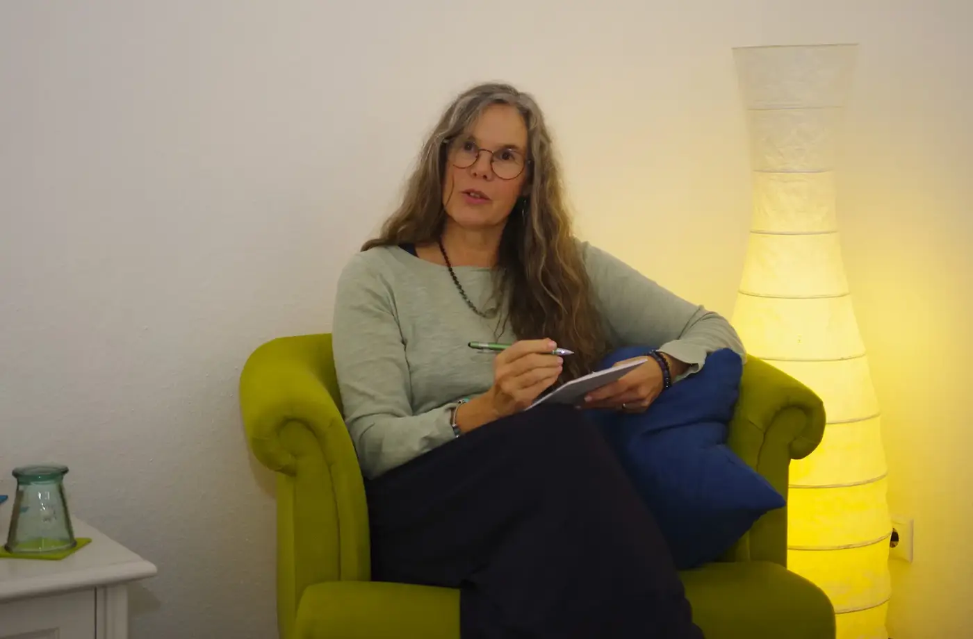 Lioba Abbenante im grünen Sessel in der Praxis